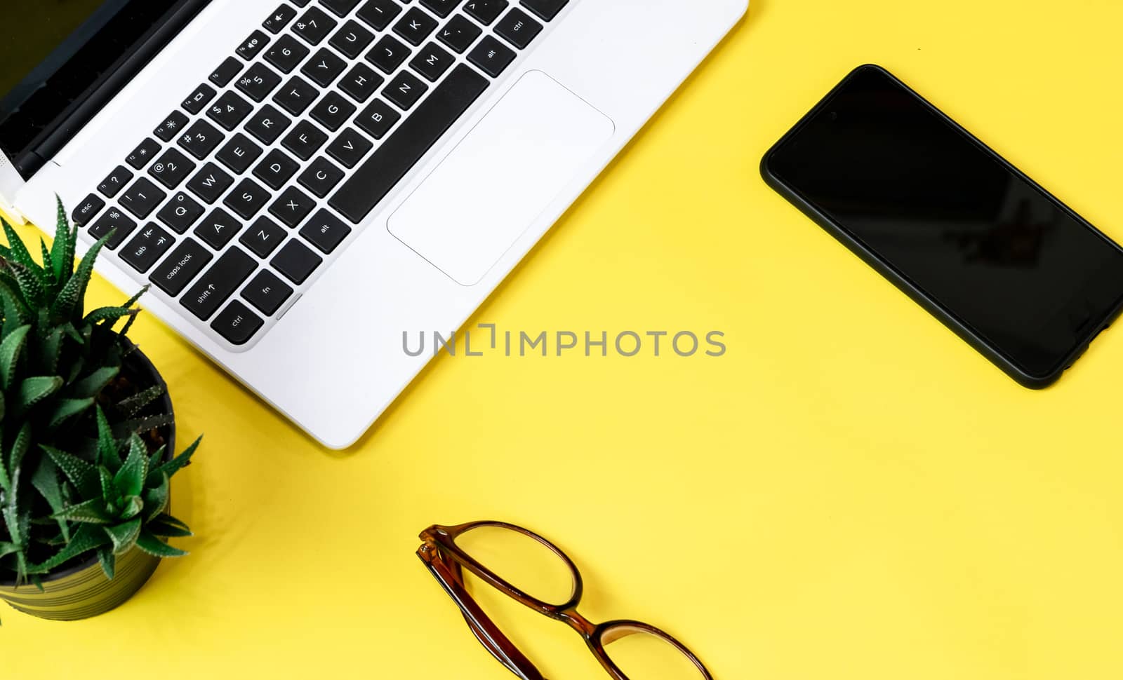 Laptop placed on a yellow table background of business working place with cup coffee, Empty workspace