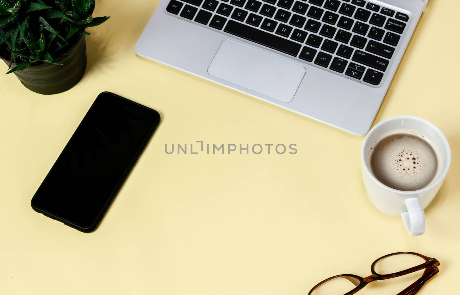 Laptop placed on a yellow table background of business working place with cup coffee, Empty workspace