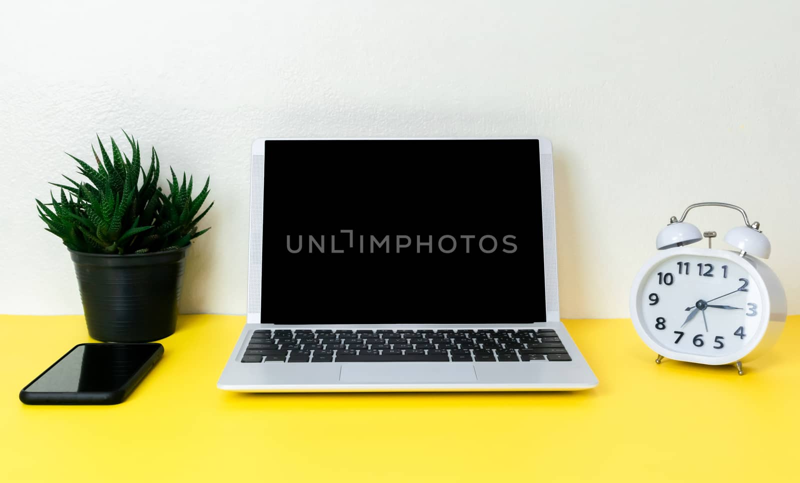 Laptop placed on a yellow table background of business working place with cup coffee, Empty workspace