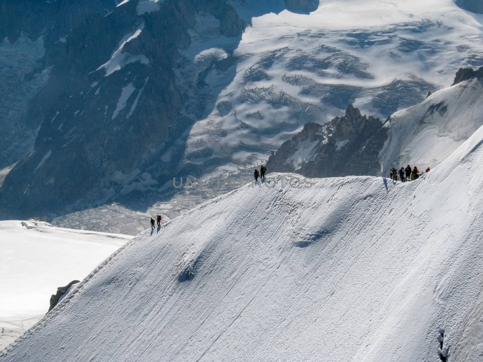 Trekkers on Aiguille Du Midi, in the french alps  by magicbones