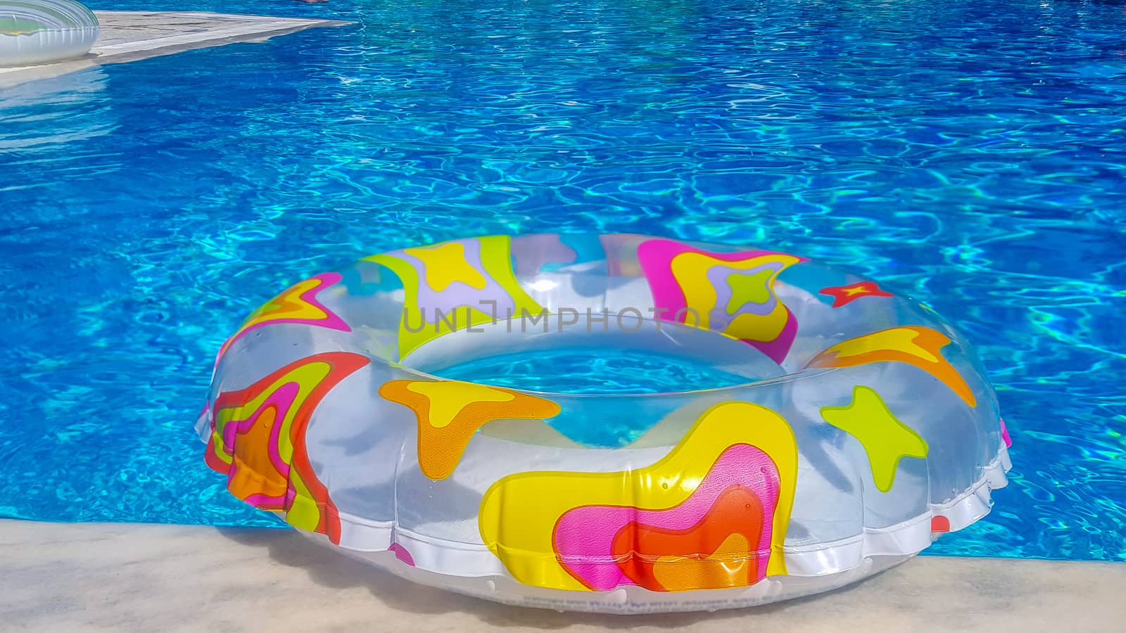 Rubber ring floating in a swimming pool by magicbones