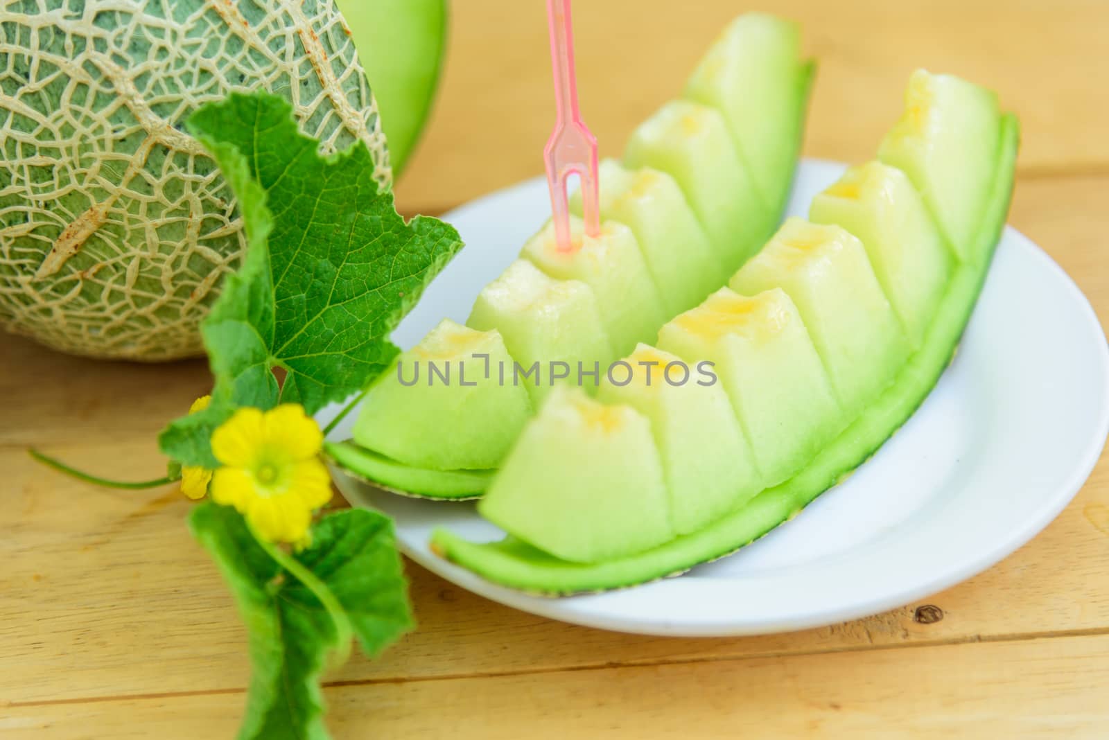 Fresh green melon on wood plate