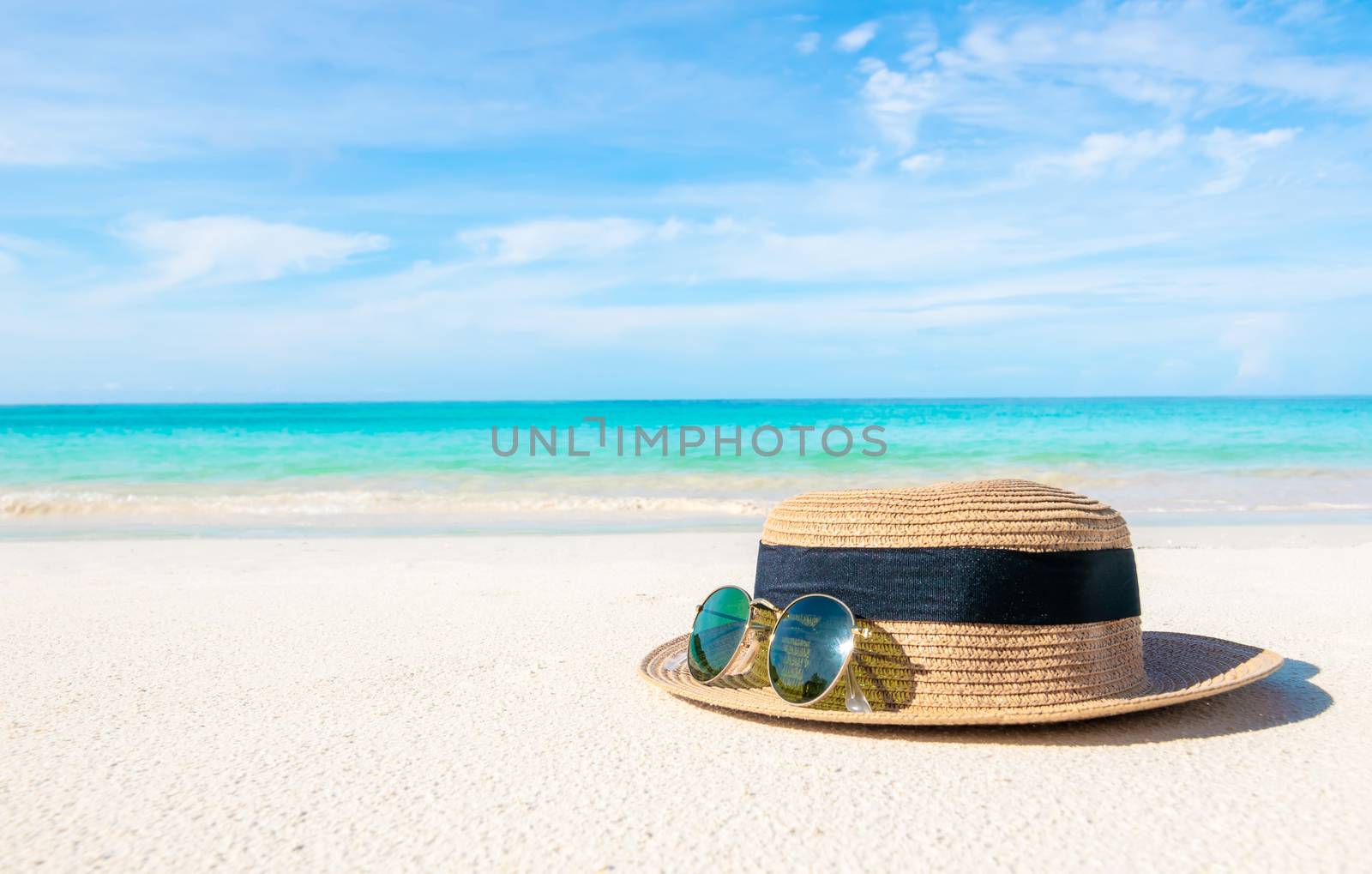 Hats and glasses placed on the beach and sea have a holiday summer relaxing and travel bright sky koh lipe thailand by sompongtom