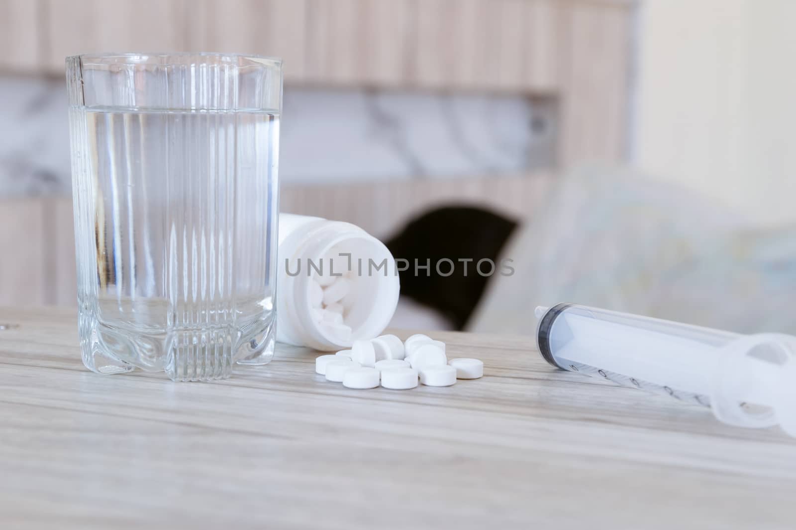Flu medicine the drug is placed on the table and a glass of water. by sompongtom