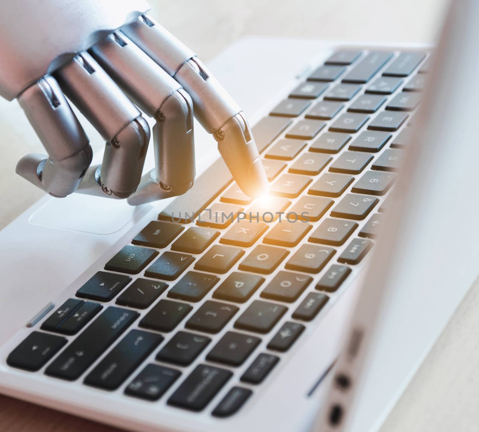 Robot hands and fingers point to laptop button advisor chatbot robotic artificial intelligence concept with light effect