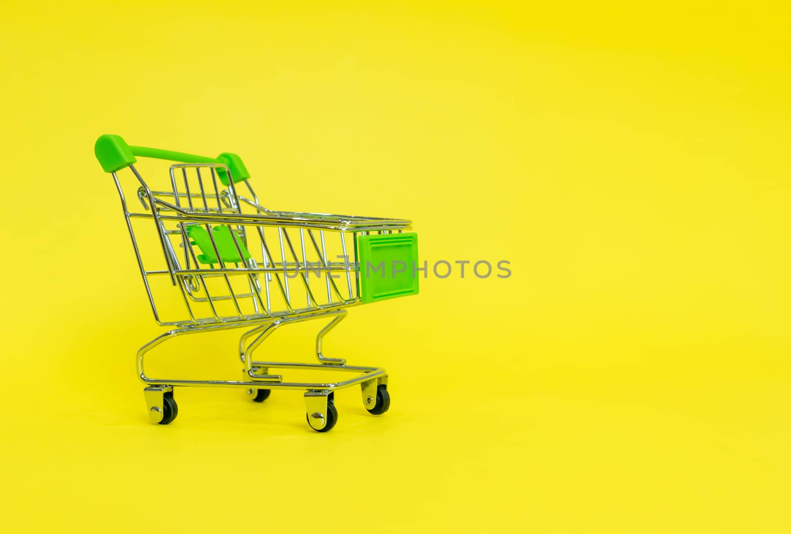 Shopping cart in the supermarket on a yellow background by sompongtom