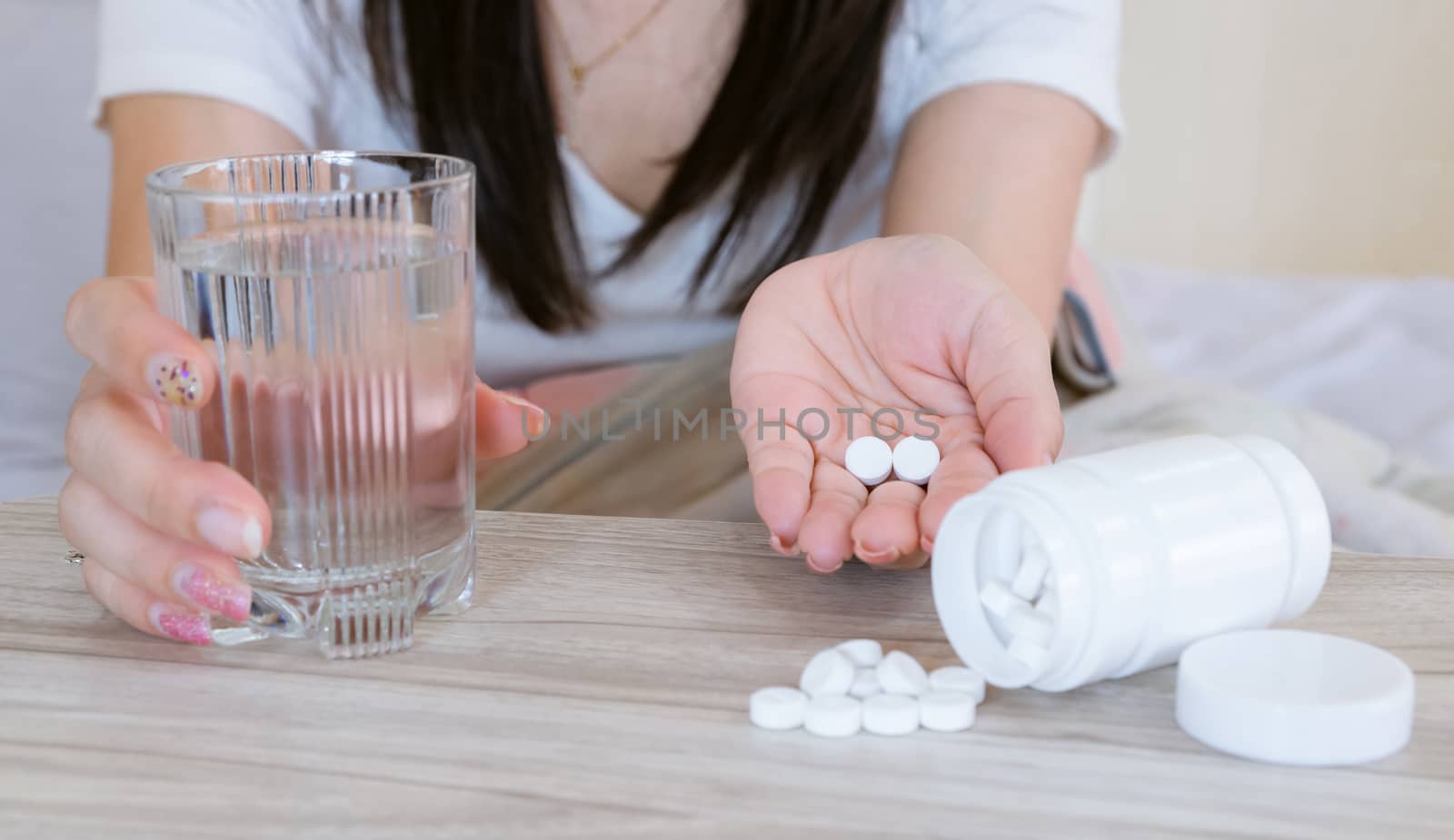 Flu medicine woman Infected With Cold the drug is placed on the table and a glass of water.