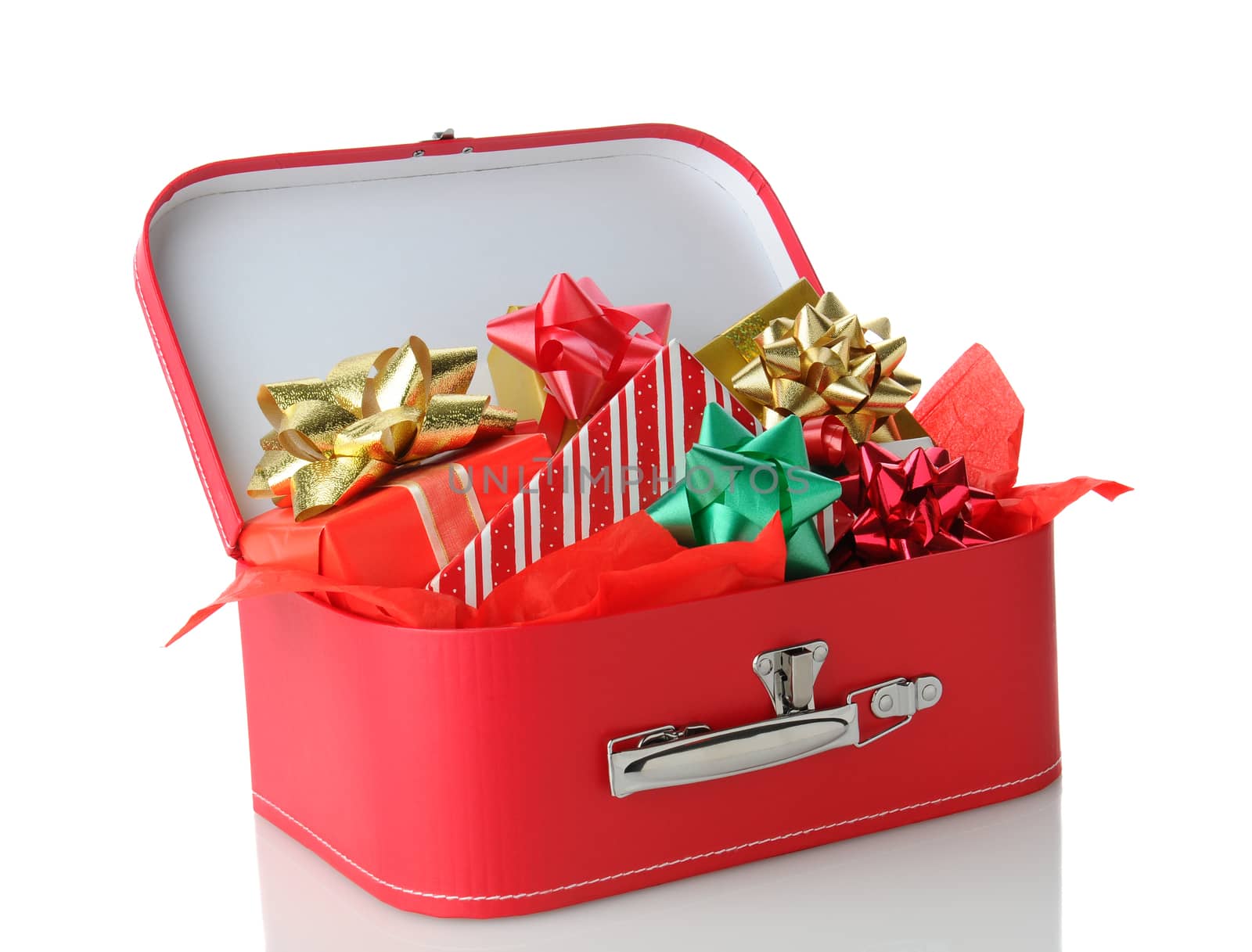 Closeup of a red suitcase full of wrapped presents. Horizontal format over a white background with reflection.