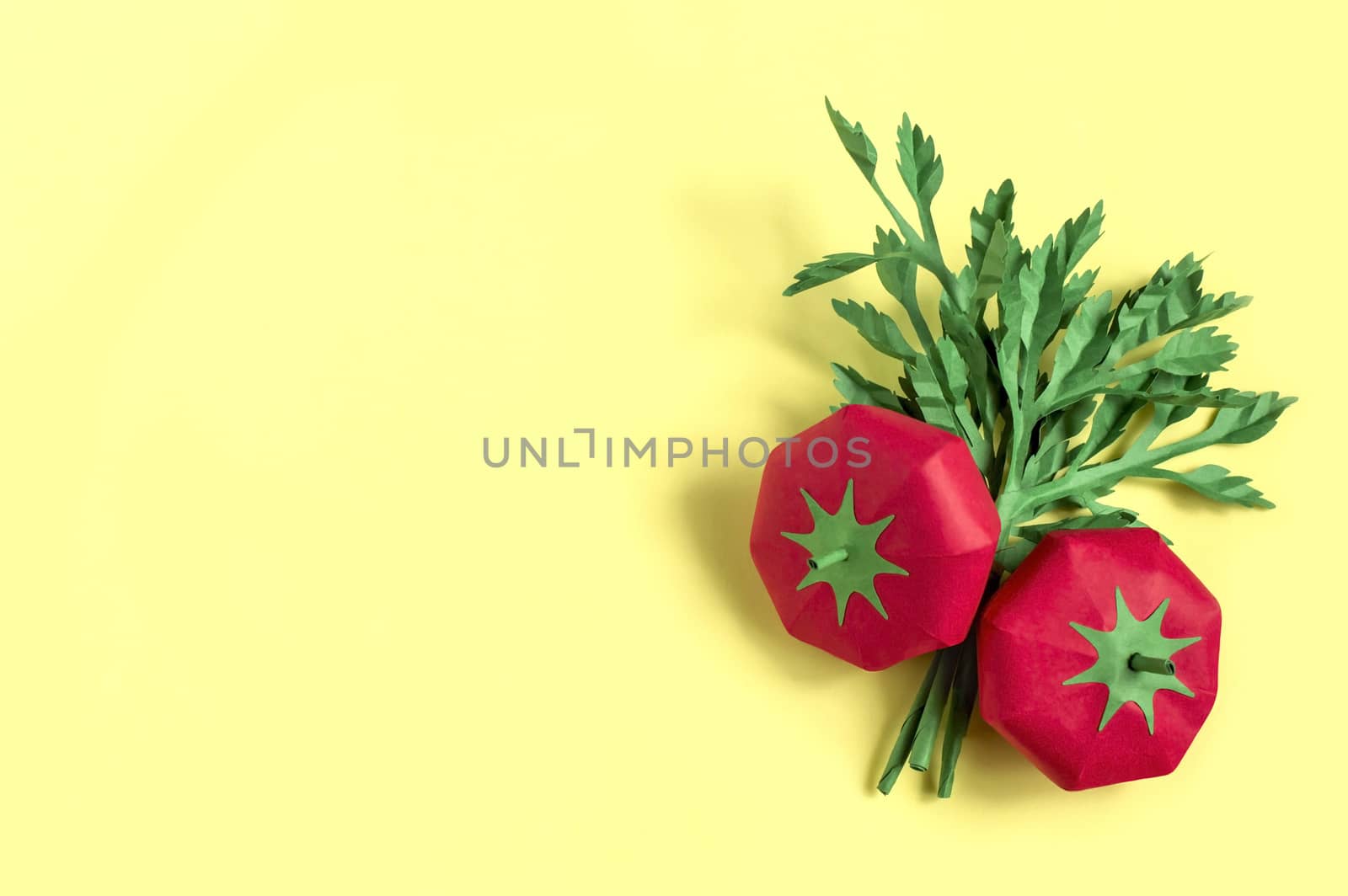 Two paper tomatoes and parsley on yellow background. Real volumetric handmade paper objects. Paper art and craft