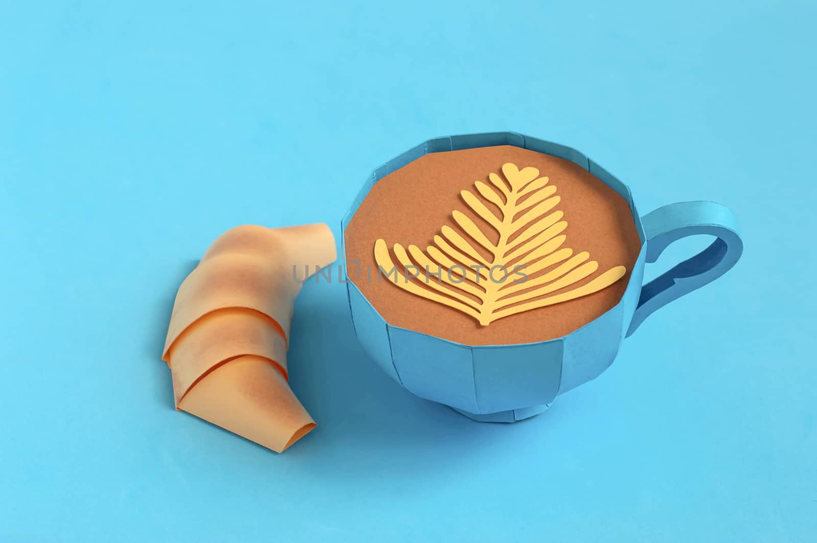 Beautiful blue paper cup with cappuccino and paper croissant. Real volumetric handmade paper objects. Paper art and craft