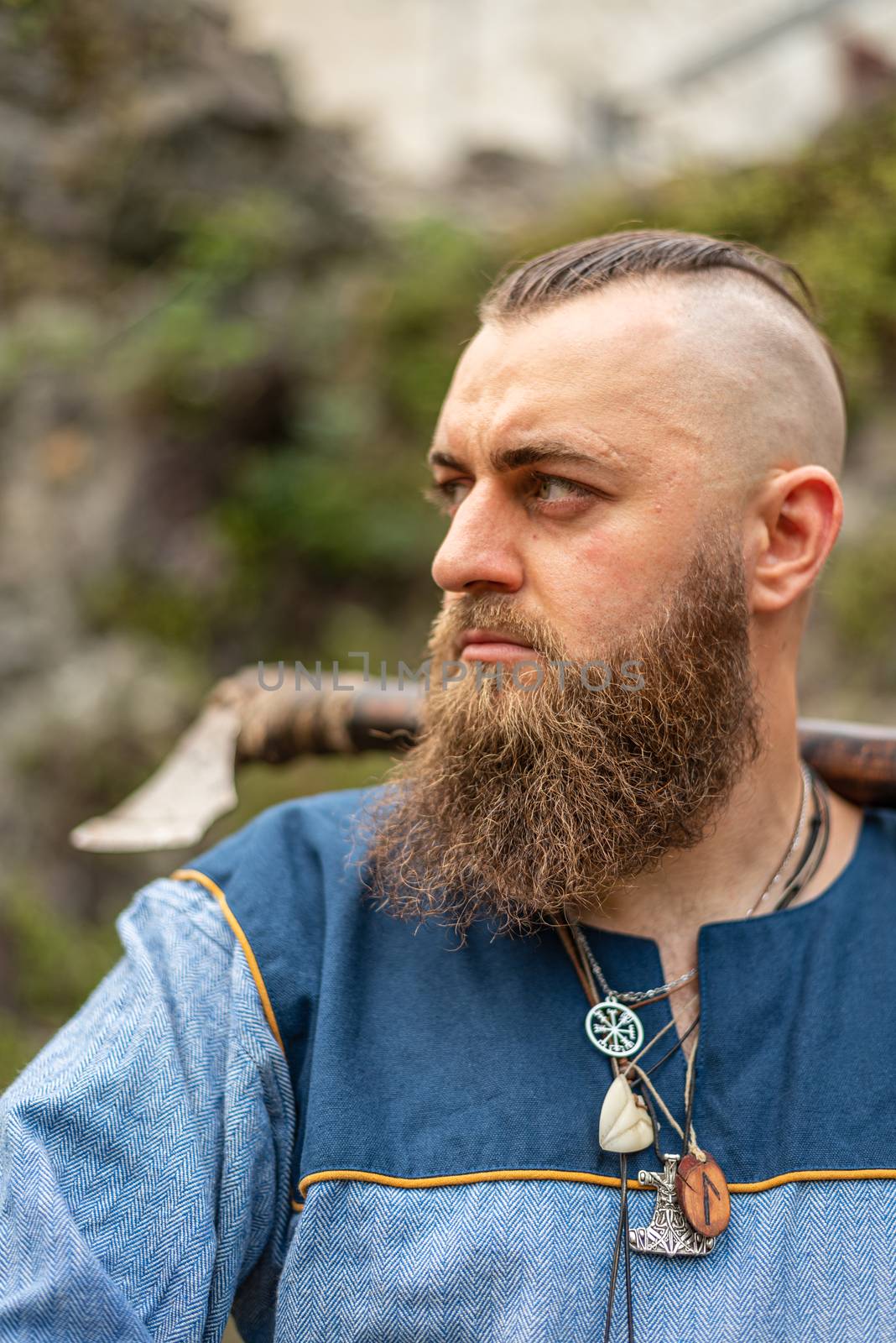 Portrait of a Viking warrior with a long beard with ax and amulets around his neck