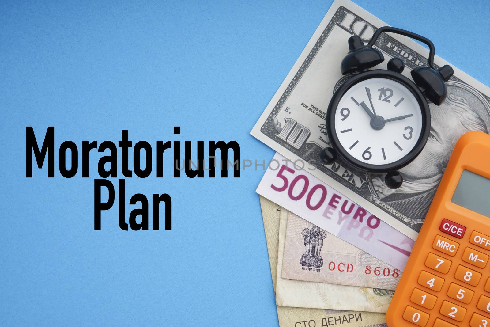 MORATORIUM PLAN text with alarm clock, banknotes currencies and calculator on blue background. Coronavirus Covid19 and Business Concept