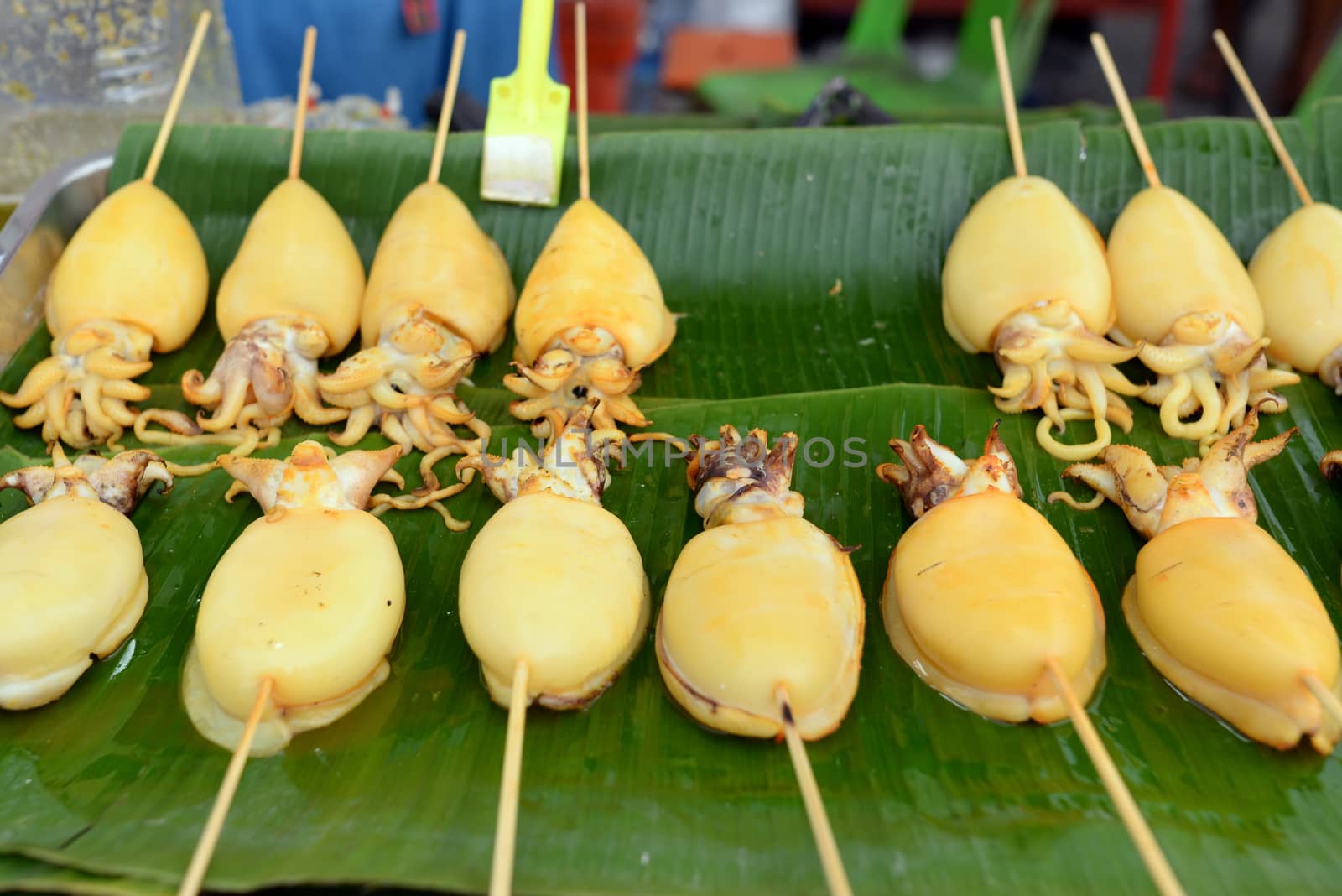 Squid carapace, skewers placed on a green banana leaf for sale