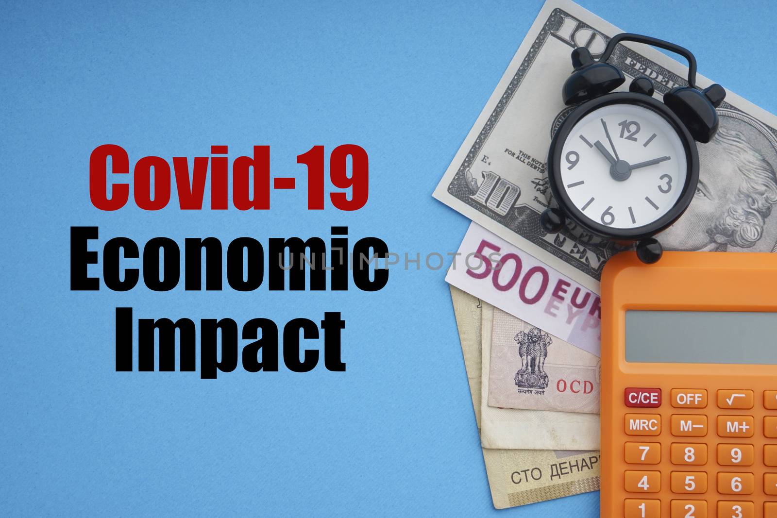 COVID19 ECONOMIC IMPACT text with alarm clock, banknotes currencies and calculator on blue background by silverwings