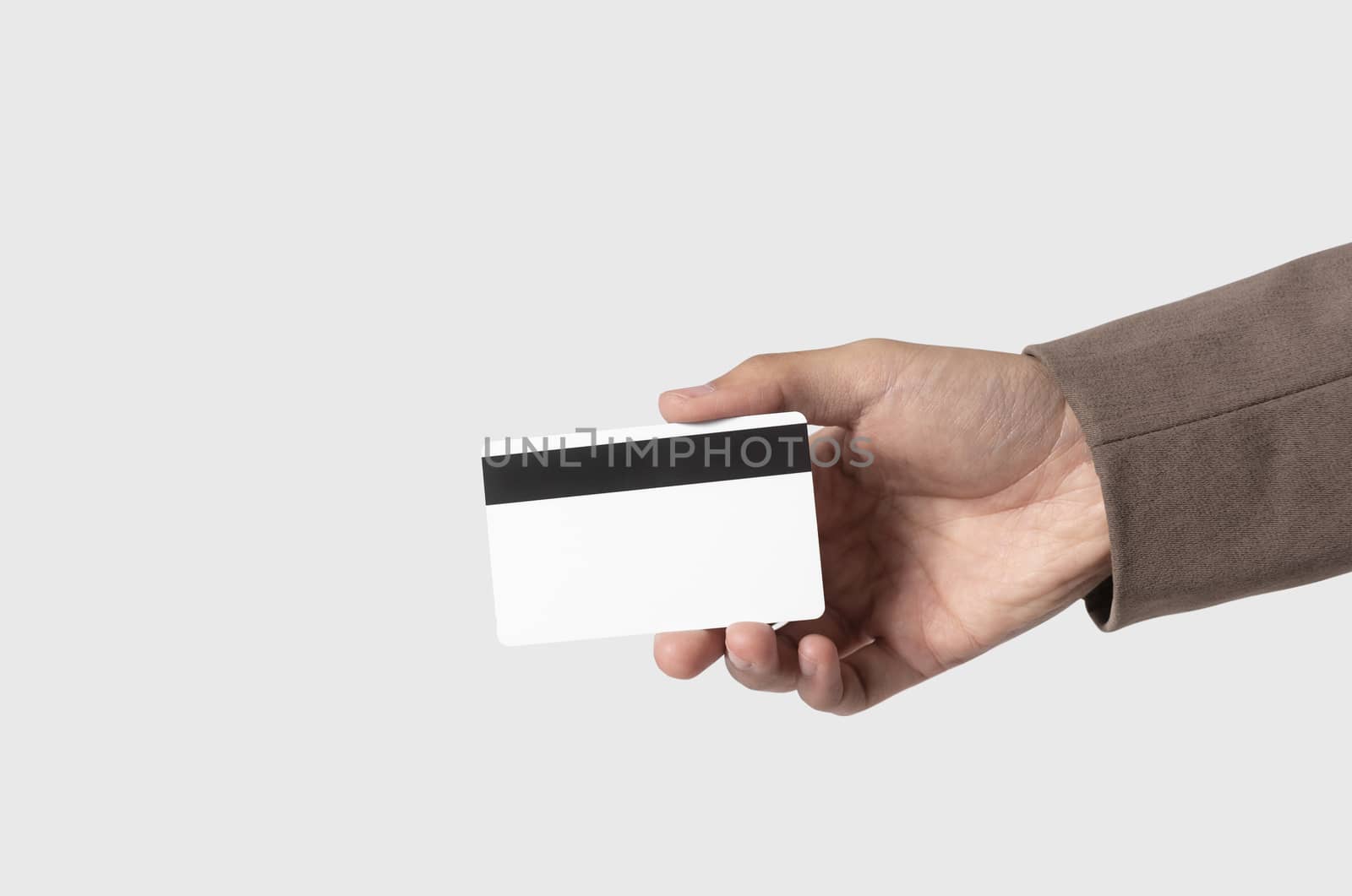 Hand holding credit card for payment money isolated on gray background.