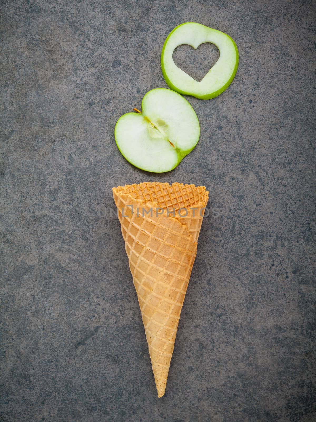 Apple slice in waffle cones and heart shape of apple setup on dark stone background . Valentine 's day and Sweet menu concept.