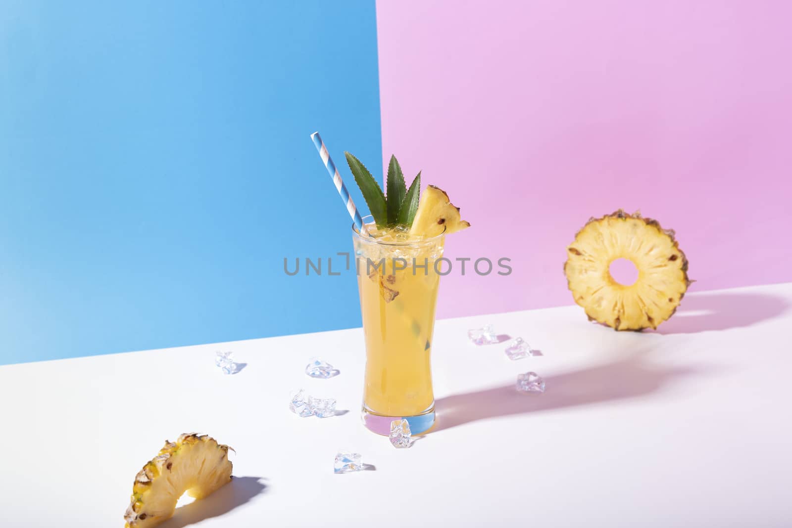 iced pineapple punch cocktail in glass on color background. summer drink.