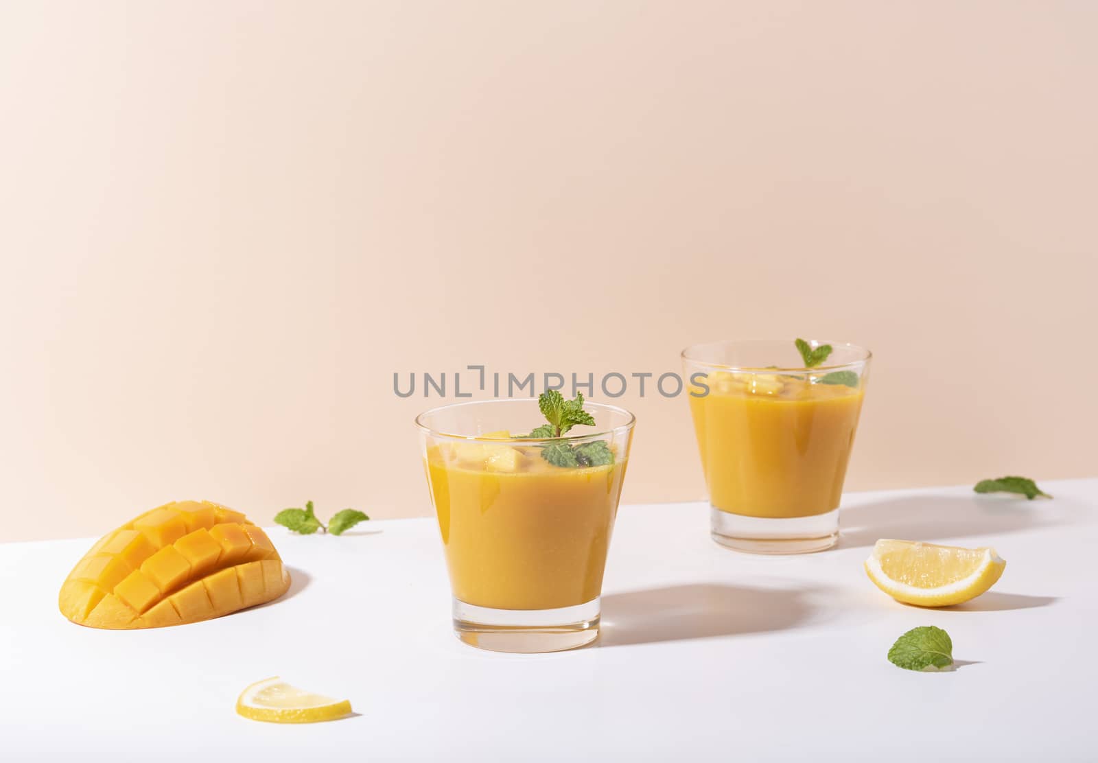 Fresh mango smoothie and ripe mango slice on color background. summer drink.