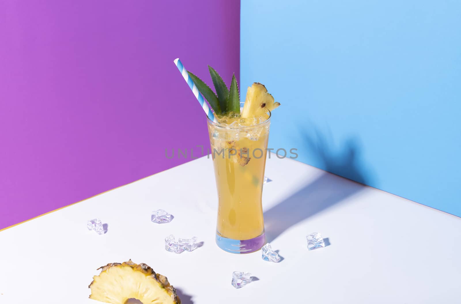 iced pineapple punch cocktail in glass on color background. summer drink.