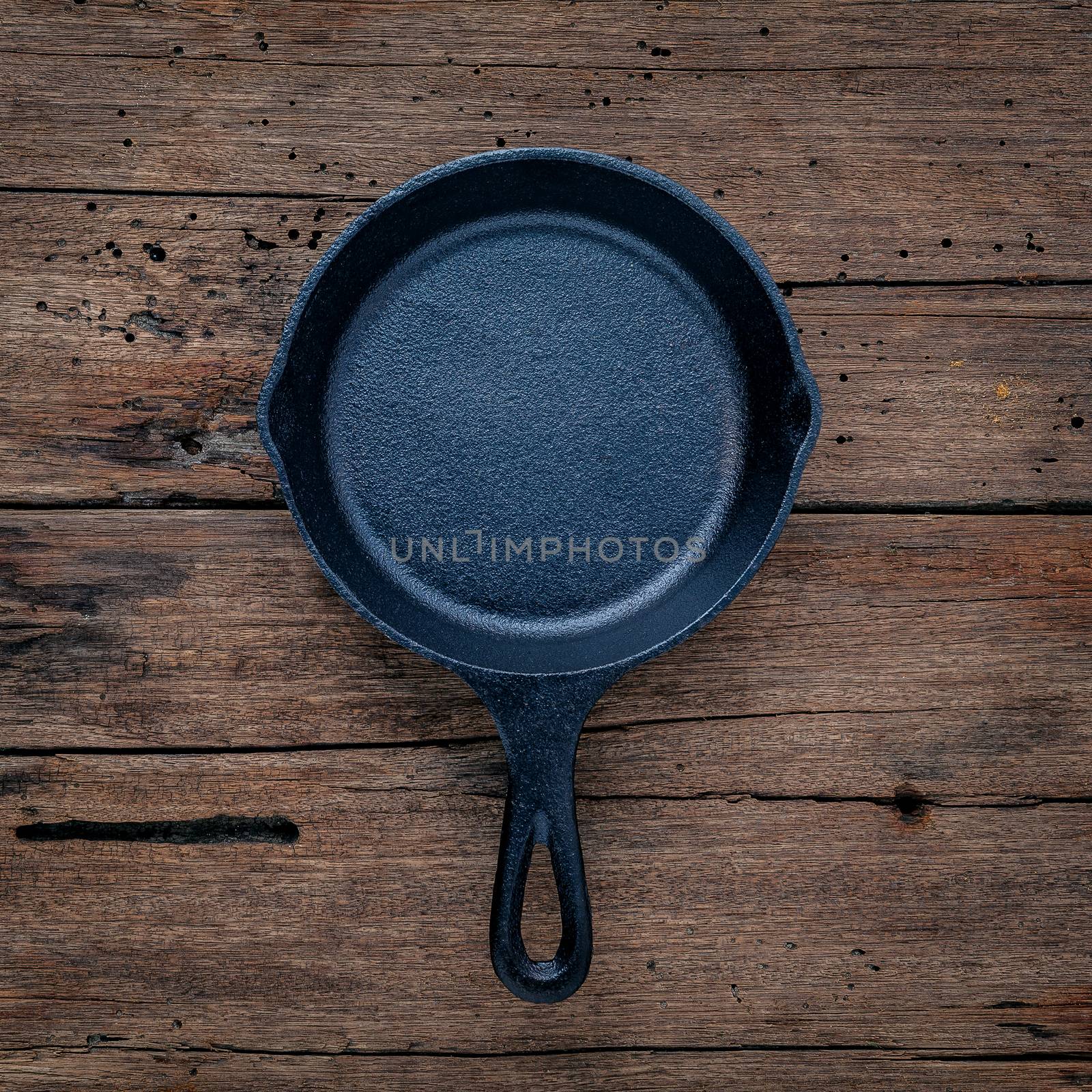The cast-iron skillet frying pan flat lay on shabby wooden background with copy space .