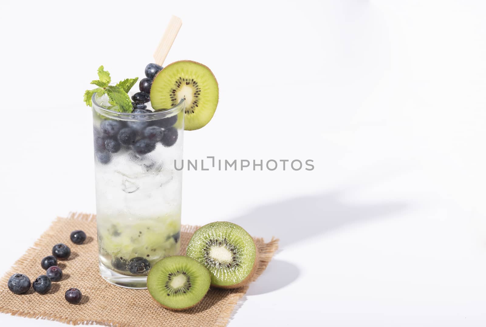 Kiwi cocktails beverage with ripe blueberry on white background. summer drink.