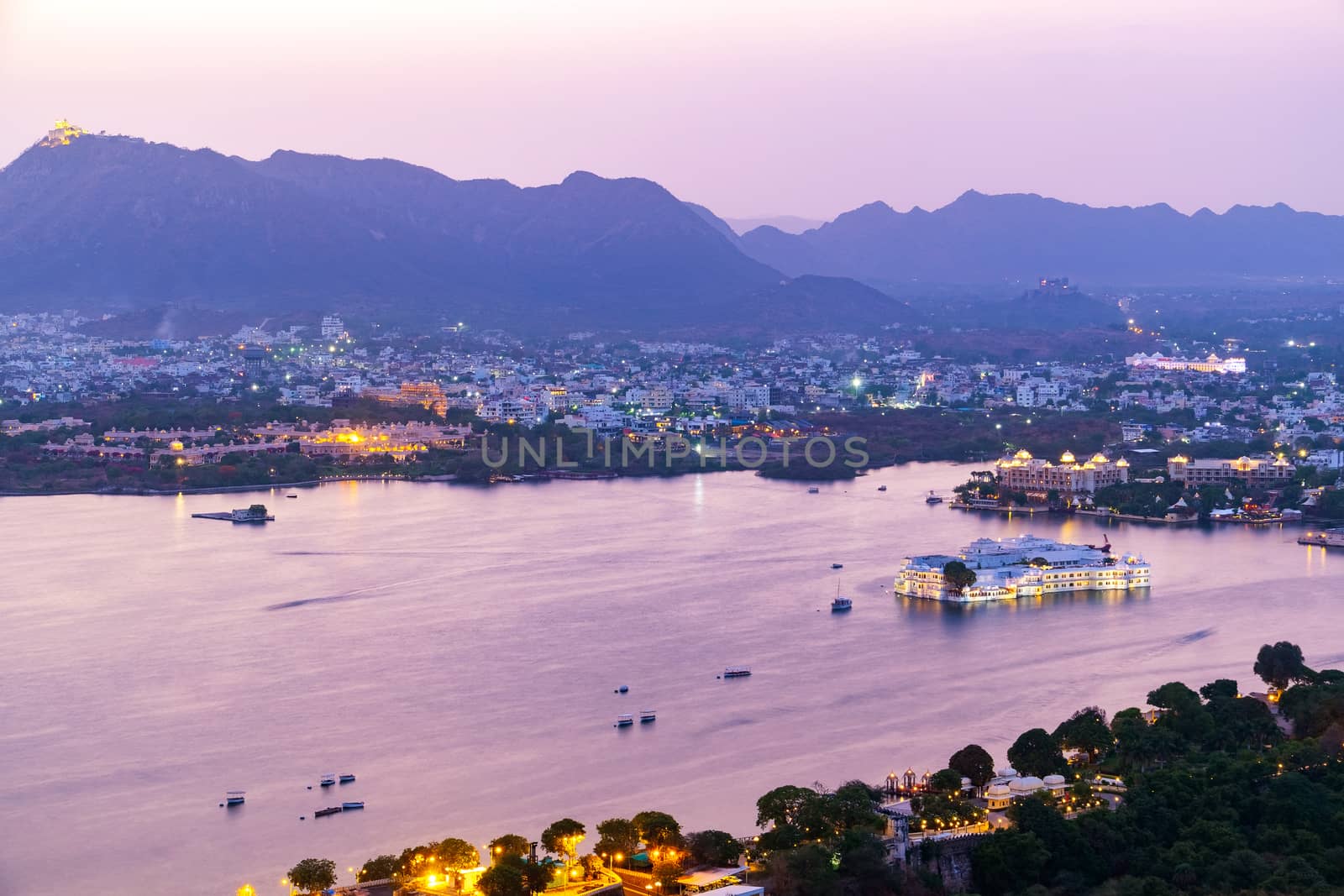 Udaipur city at lake Pichola in the evening, Rajasthan, India. View from  the mountain viewpoint see the whole city reflected on the lake.