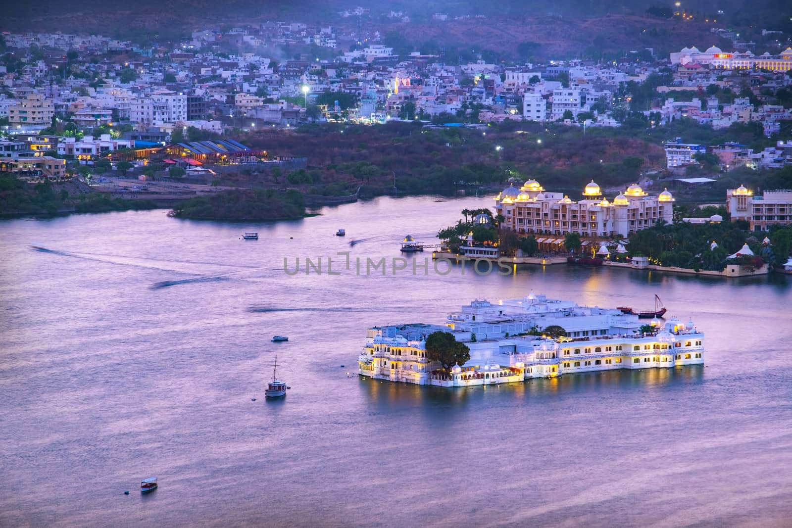 Udaipur city at lake Pichola in the evening, Rajasthan, India. View from  the mountain viewpoint see the whole city reflected on the lake.