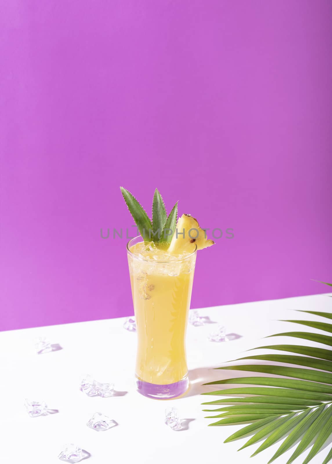 iced pineapple punch cocktail in glass on color background. summer drink.