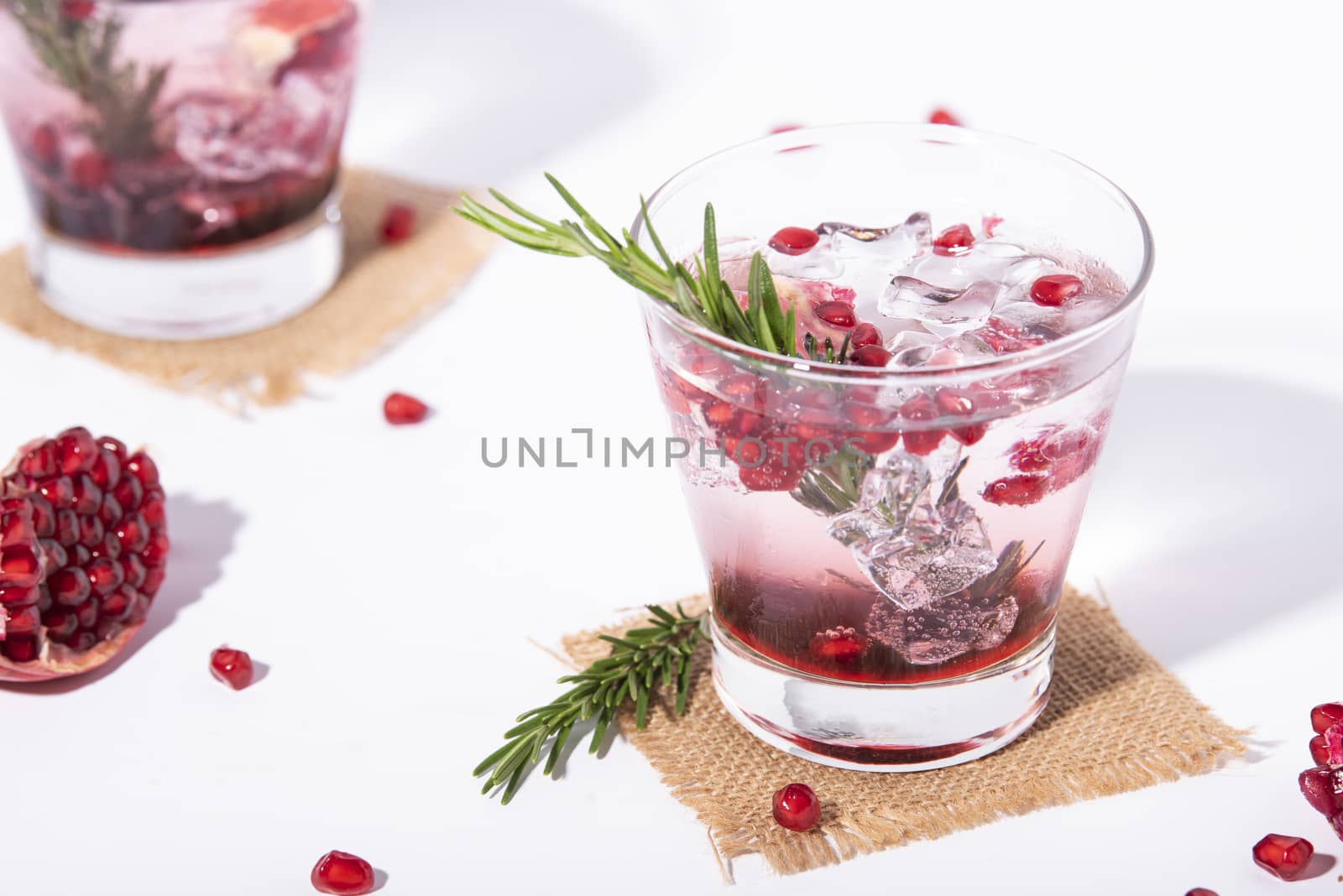 Pomegranate juice with ripe pomegranate on white background. summer drink.