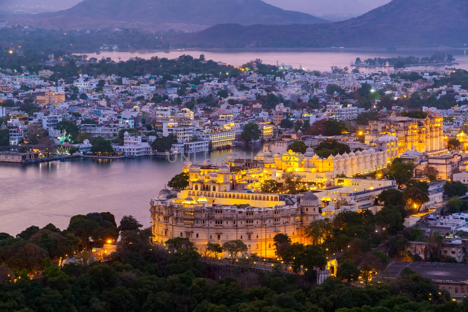 Udaipur city at lake Pichola in the evening, Rajasthan, India. View from  the mountain viewpoint see the whole city reflected on the lake.