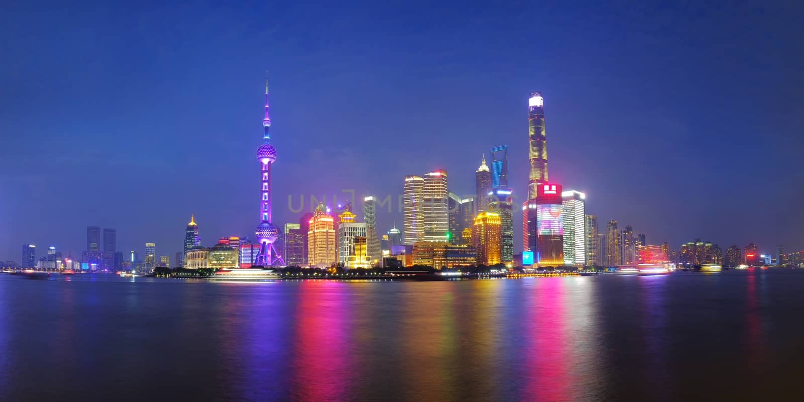 Shanghai city skyline Pudong side looking through Huangpu river on twilight time. Shanghai, China. Beutiful vibrant panoramic image.