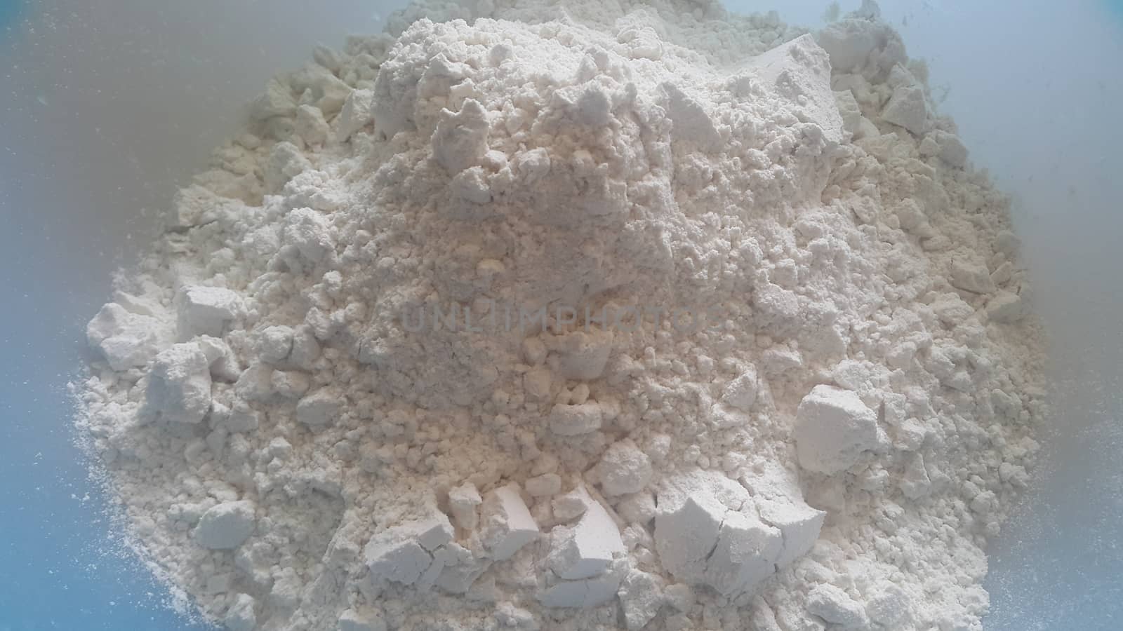 Closeup view of wheat flour heap placed in market for sale. by Photochowk