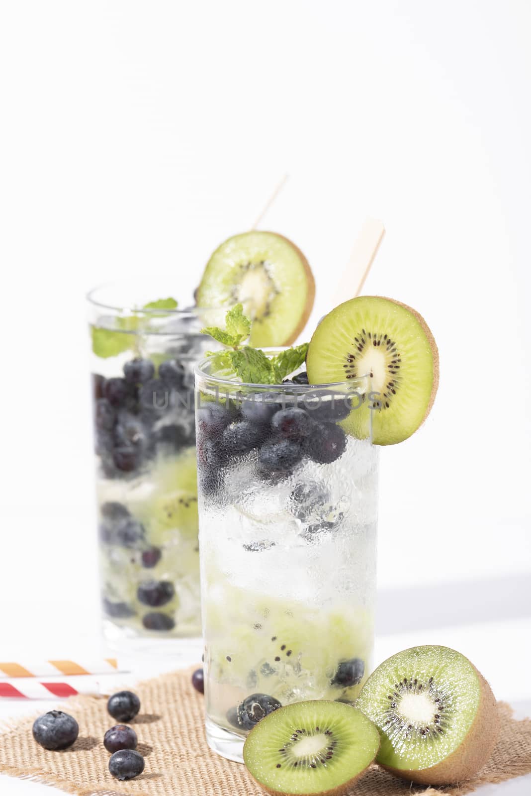 Kiwi cocktails beverage with ripe blueberry on white background. summer drink.