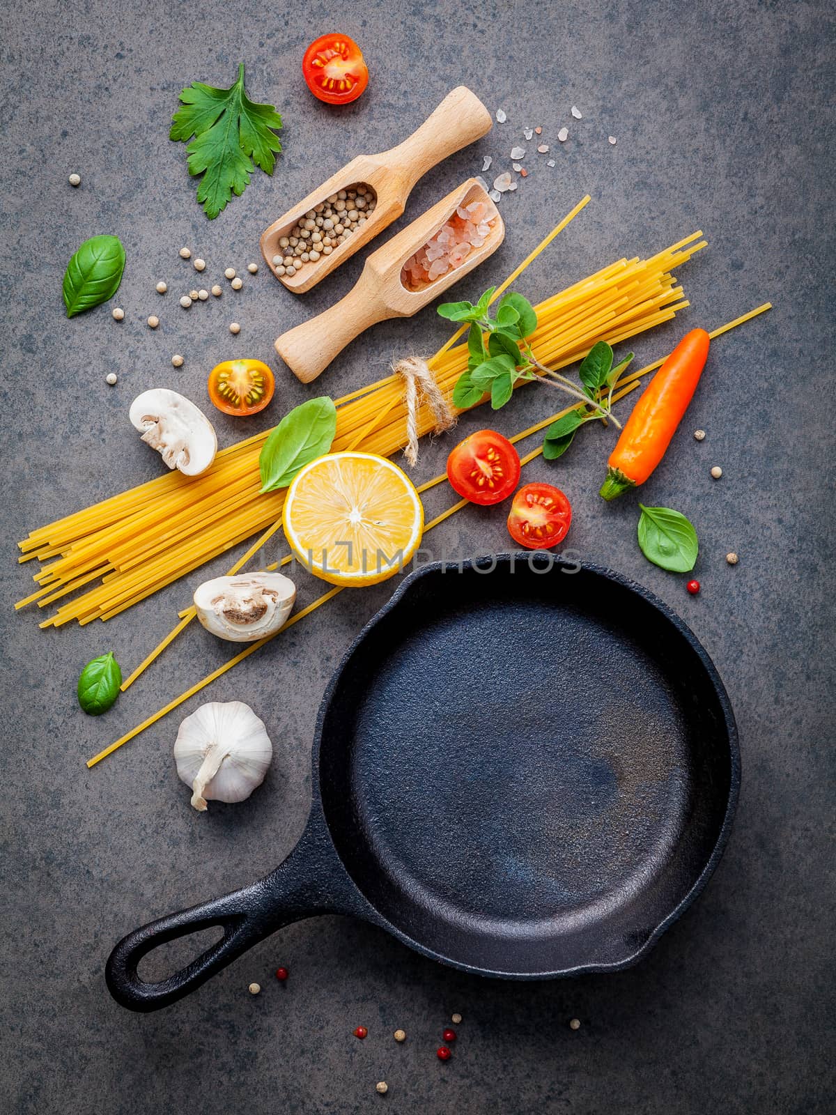 Italian food and menu concept. Spaghetti with ingredients sweet basil ,tomato ,garlic peppercorn and champignon on dark background flat lay and copy space.