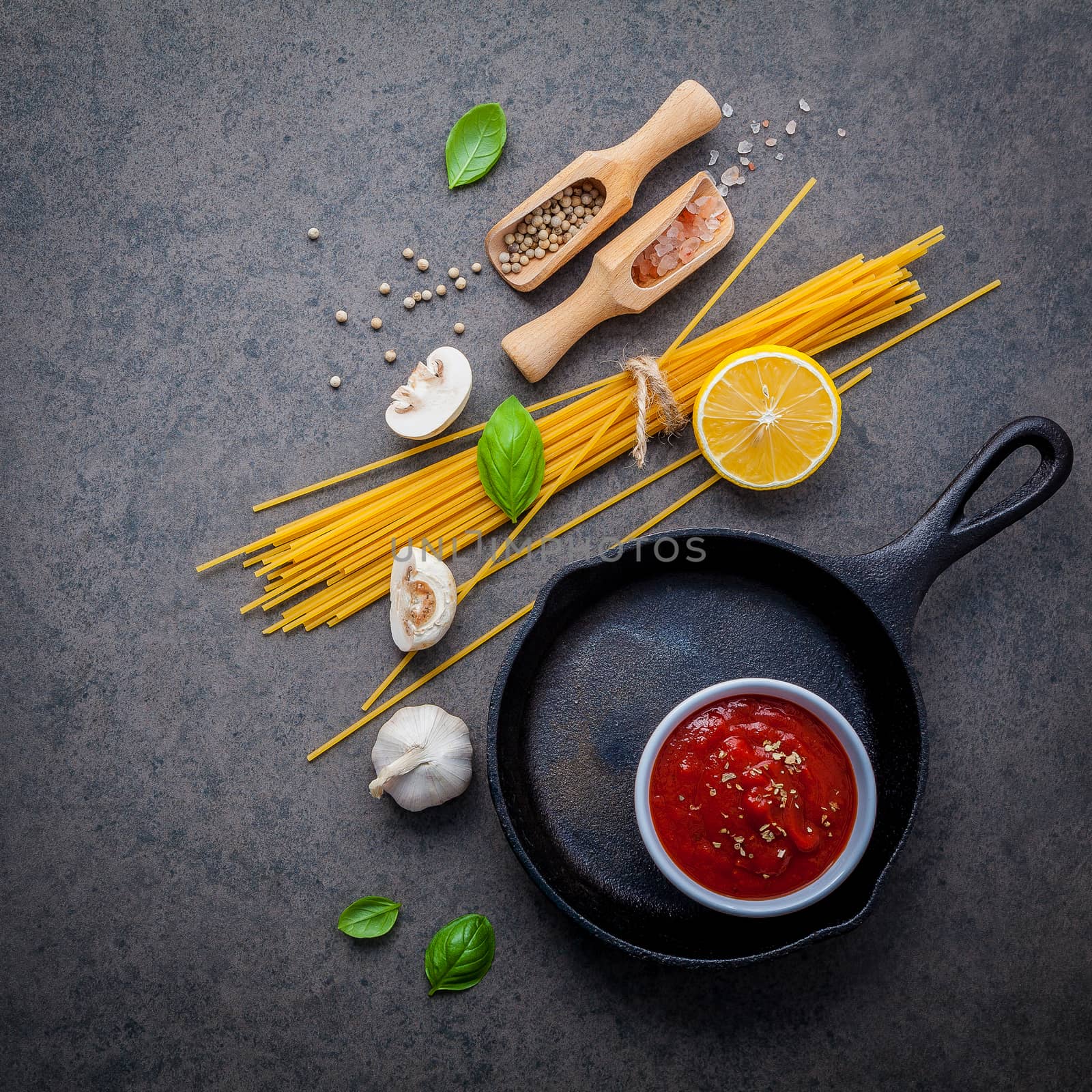 Italian food and menu concept. Spaghetti with ingredients sweet basil ,tomato ,garlic peppercorn and champignon on dark background flat lay and copy space.