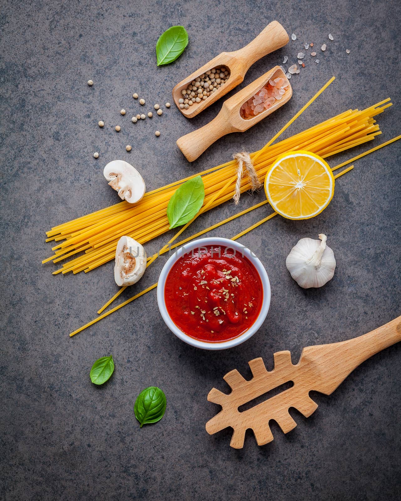 Italian food and menu concept. Spaghetti with ingredients sweet basil ,tomato ,garlic peppercorn and champignon on dark background flat lay and copy space.