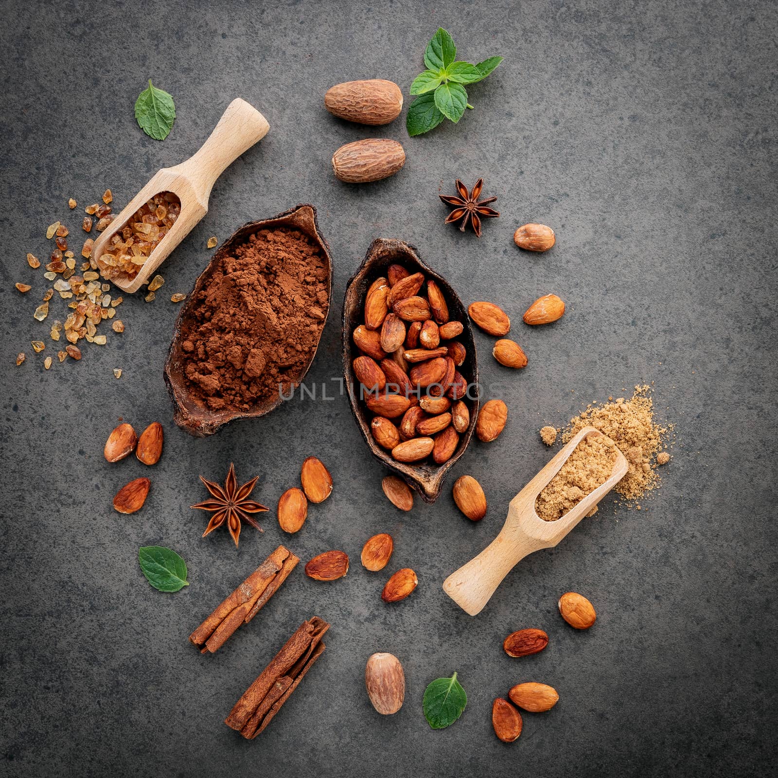 Cocoa powder and cacao beans on stone background.