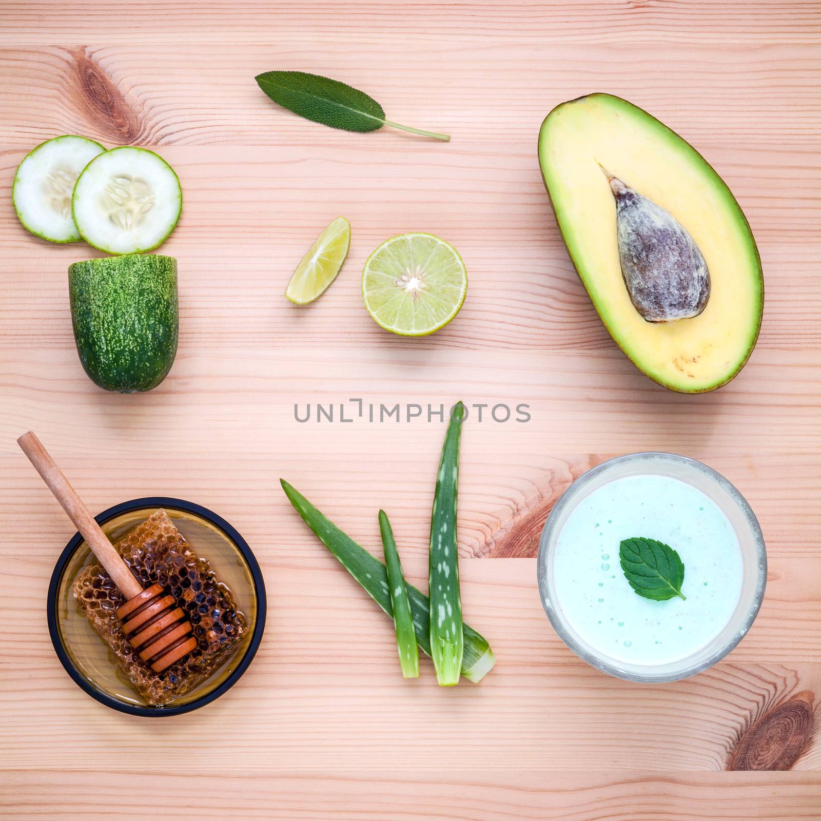 Homemade skin care and body scrub with natural ingredients avocado ,aloe vera ,lemon,cucumber and honey set up on wooden background.