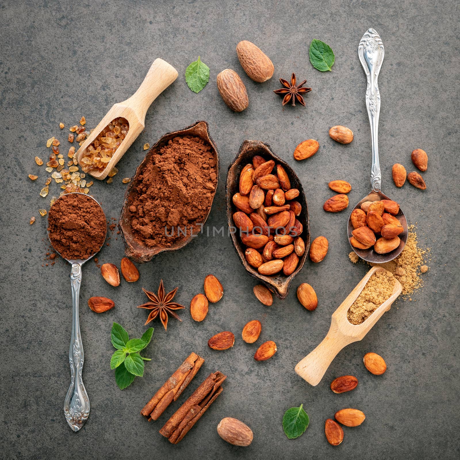 Cocoa powder and cacao beans on stone background.