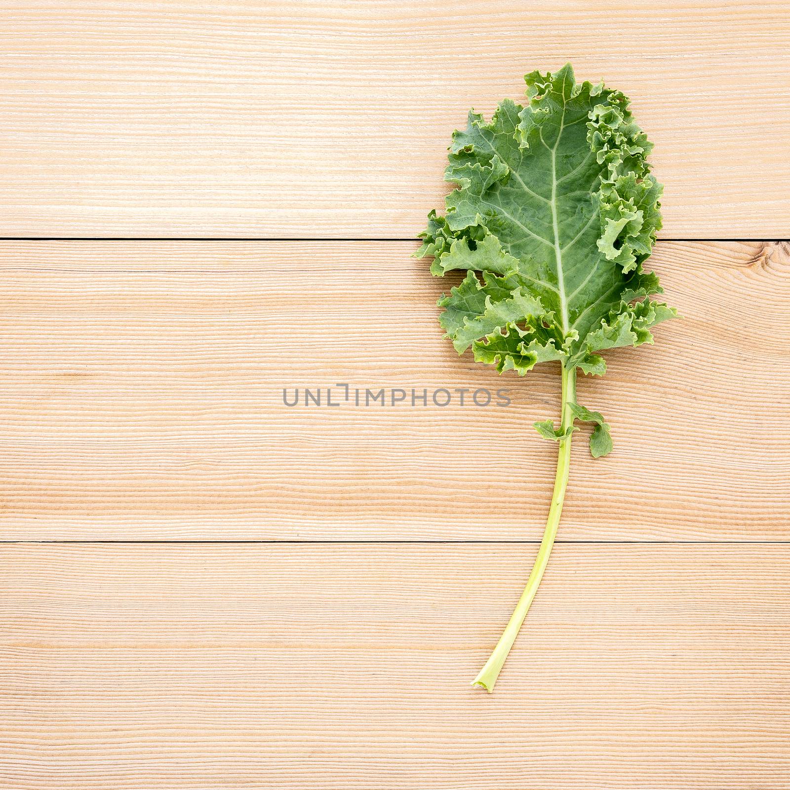 Fresh organic curly kale leaves flat lay on a wooden table with  by kerdkanno