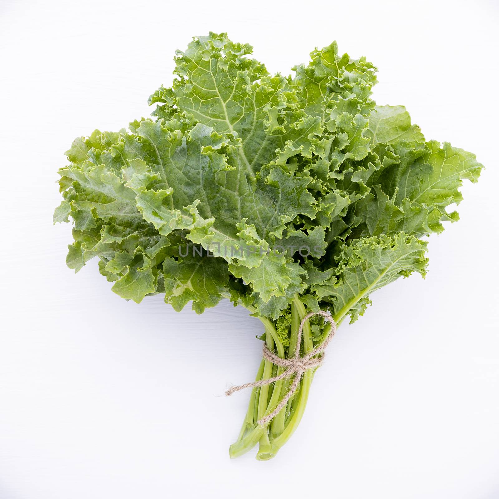 Fresh organic curly kale leaves flat lay on a wooden table with  by kerdkanno