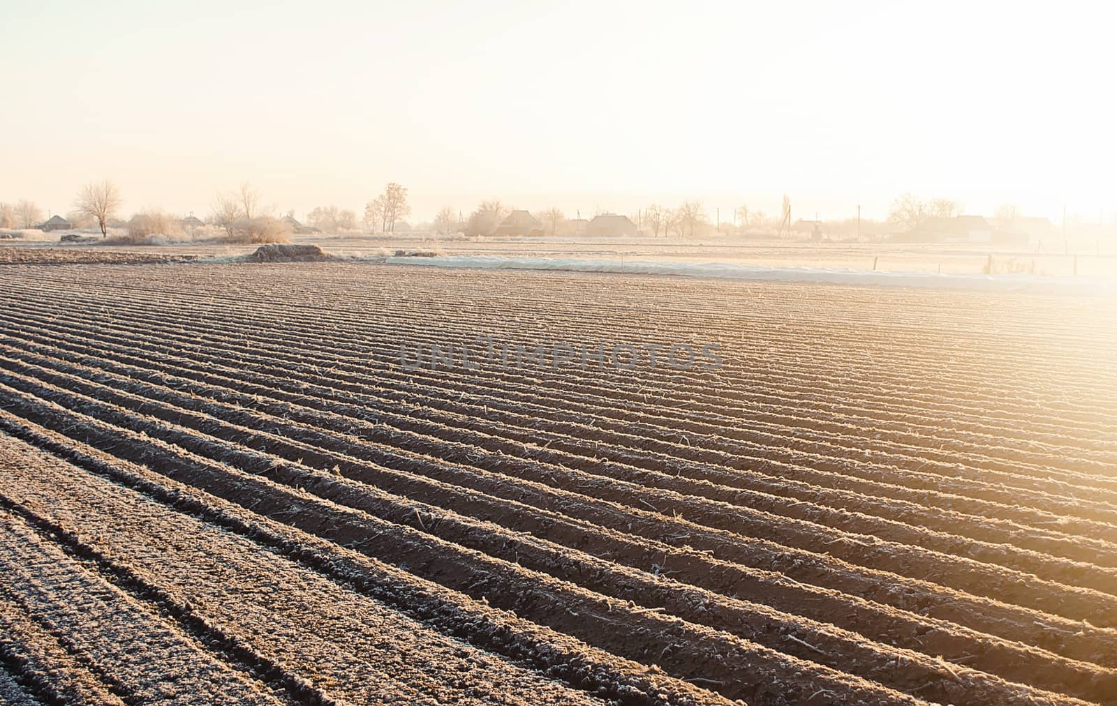 Winter farm field ready for new planting season. Preparatory agricultural work for spring. Choosing right time for sow fields plant seeds, protection from spring frosts. Agriculture and agribusiness. by iLixe48