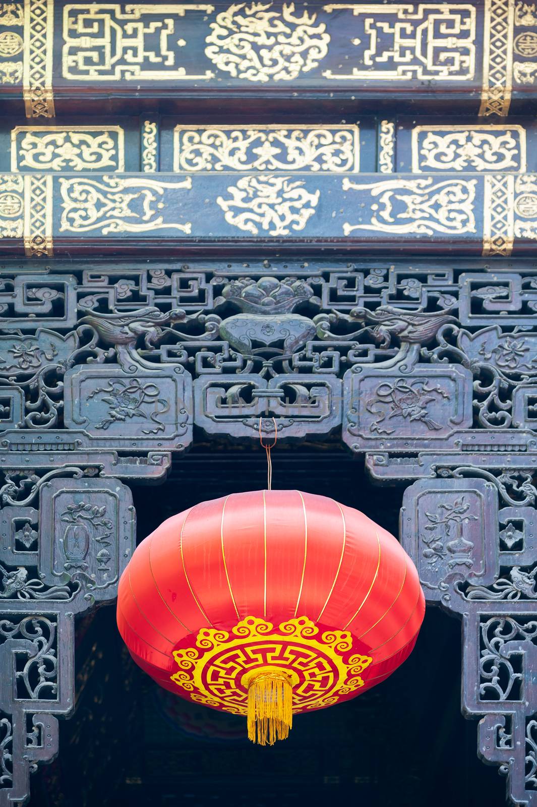 Red chinese lanterns hanging on a decorated door in LuoHanSi buddhist temple, Chongqing, China