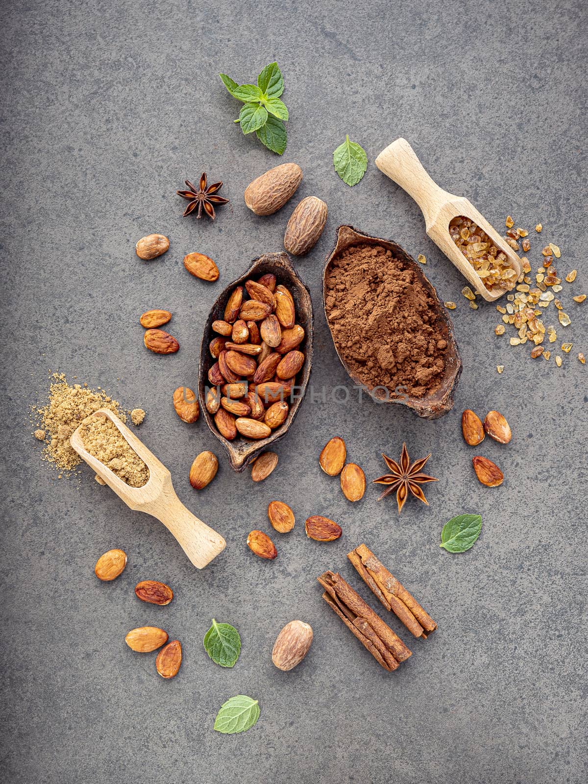 Cocoa powder and cacao beans on stone background.