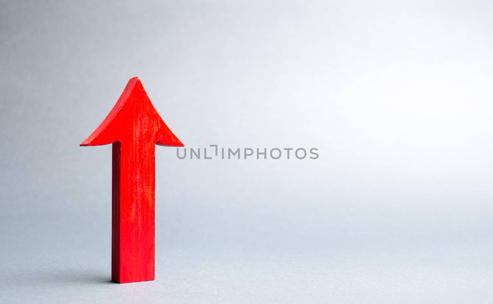 Red up arrow on gray background. The concept of growth and development, self-development. Raising work wages and living standards. Growth of economic indicators. Achievement of success.