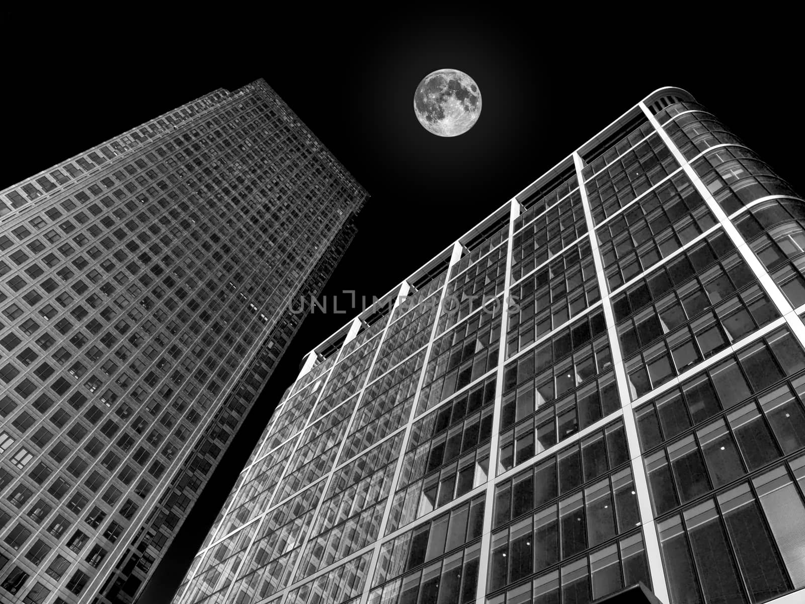 Modern futuristic tower block office skyscraper buildings architecture at night with a full moon