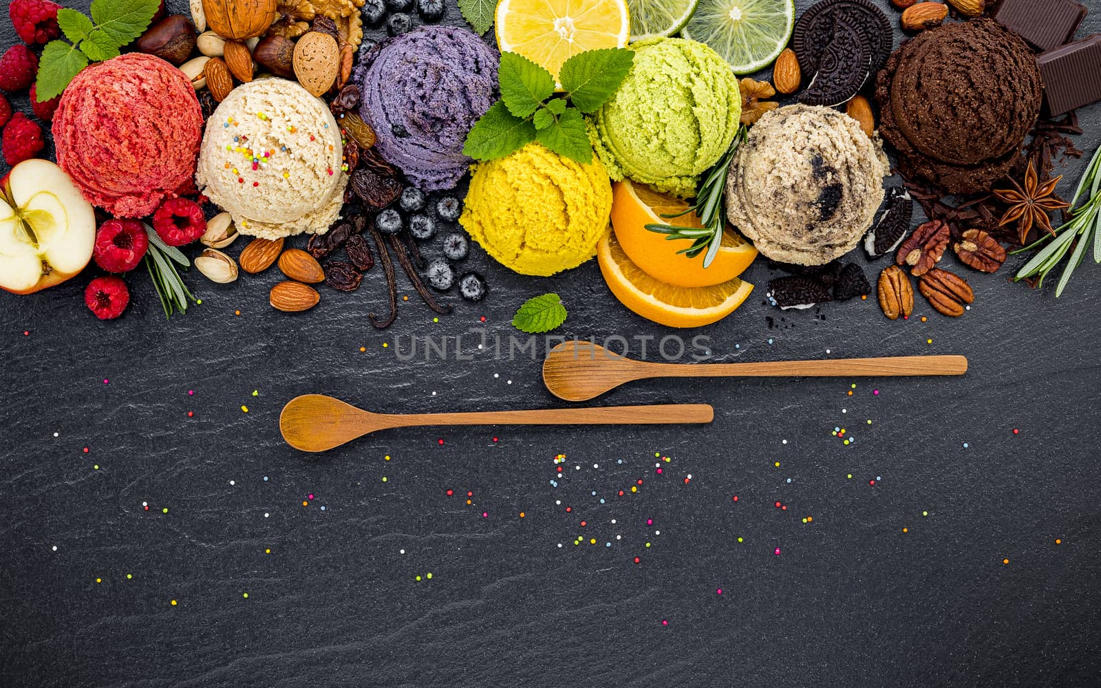 Various of ice cream flavor ball blueberry ,lime ,pistachio ,almond ,orange ,chocolate and vanilla set up on dark stone background . Summer and Sweet menu concept.