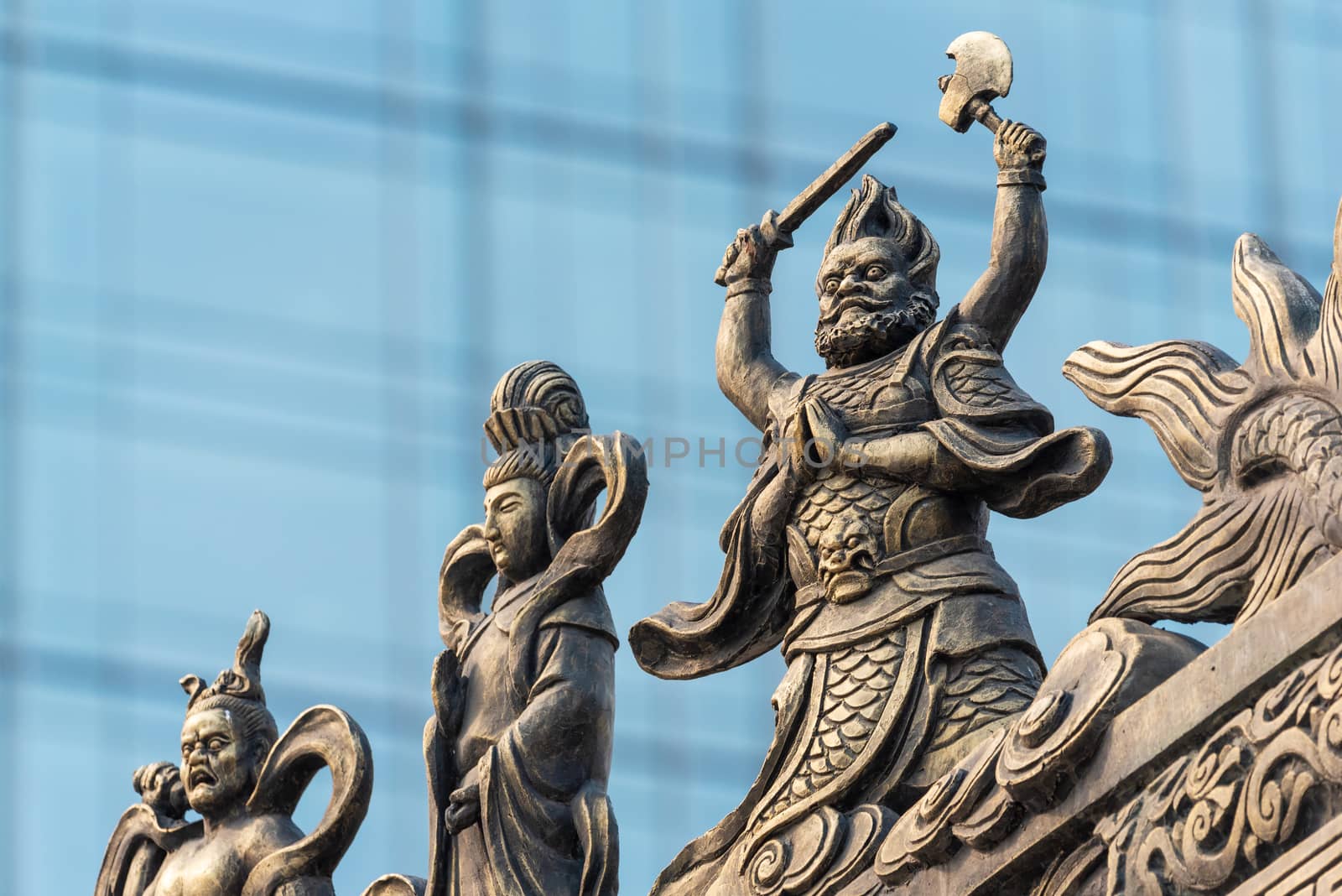 Decoration sculpture on Daci buddhist temple roof against modern building in Chengdu, China