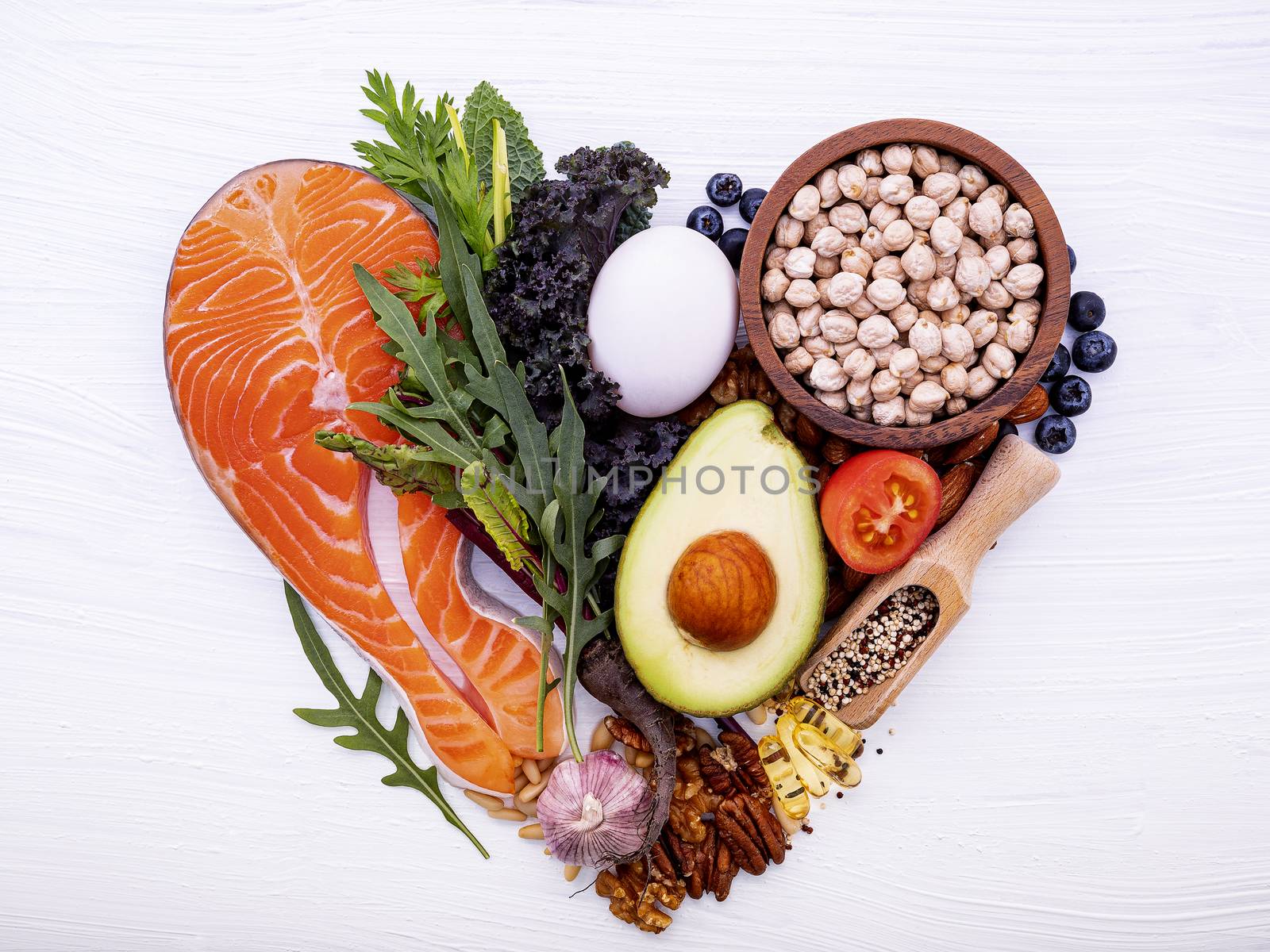 Heart shape of ketogenic low carbs diet concept. Ingredients for healthy foods selection on white wooden background. Balanced healthy ingredients of unsaturated fats for the heart and blood vessels.