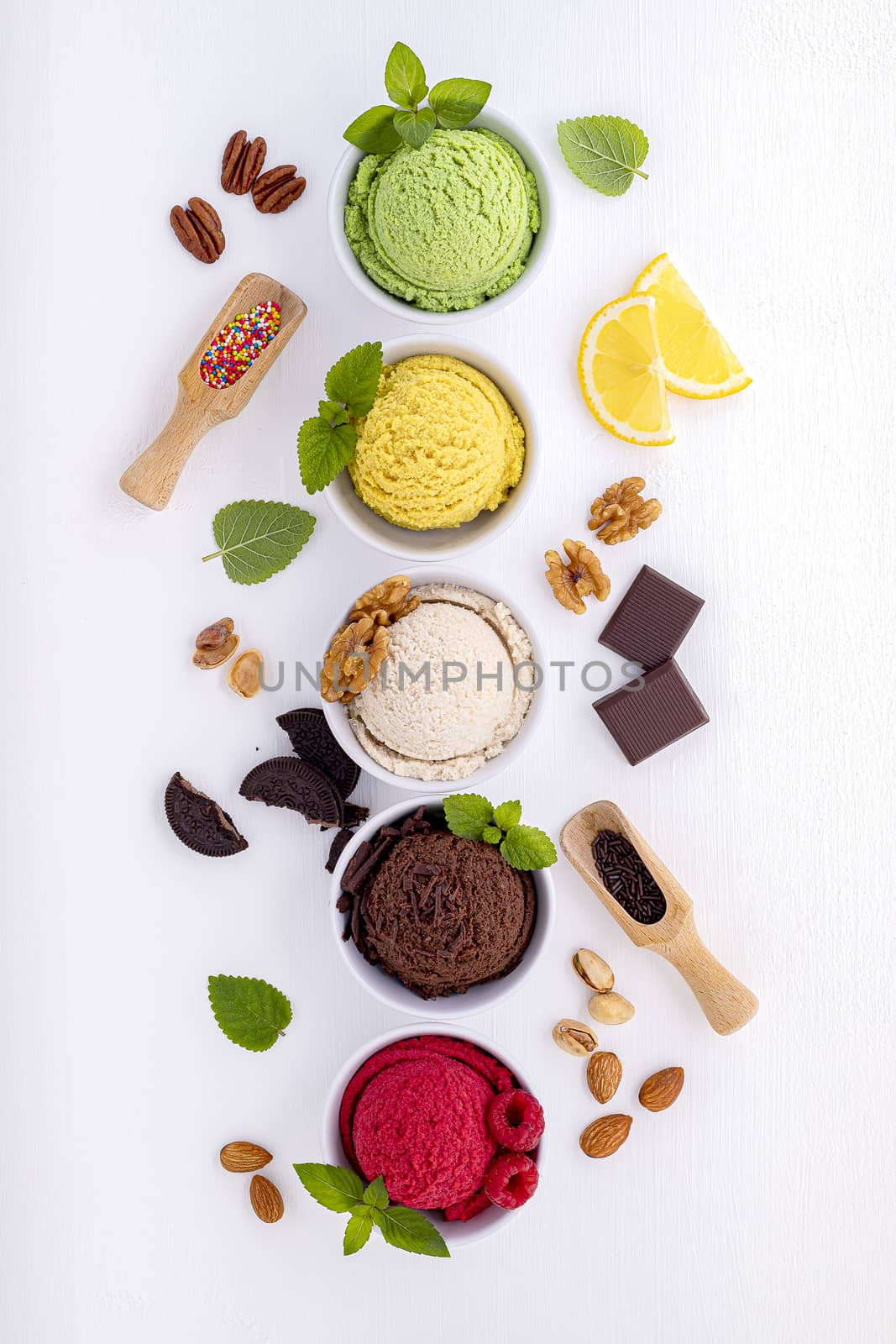 Various of ice cream flavor ball blueberry ,lime ,pistachio ,almond ,orange ,chocolate and vanilla set up on white wooden background . Summer and Sweet menu concept.